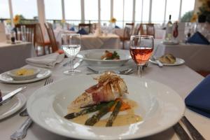 a plate of food on a table with glasses of wine at The Riviera Hotel & Apartments - Alum Chine in Bournemouth