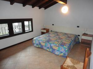 een slaapkamer met een bed in een kamer met ramen bij Residence Il Mulinaccio in Pievepelago