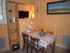 阿勒瓦的住宿－Maison des Bains，一间带桌椅和电视的用餐室