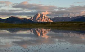 a mountain in the distance with a reflection in a pond at Oberhuberhof in Rodengo