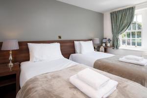 a bedroom with two beds with white towels on them at The King's Head Inn - The Inn Collection Group in Great Ayton