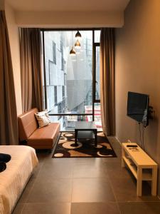 Habitación de hotel con cama, sofá y TV en Empire Damansara Residence Suites en Petaling Jaya