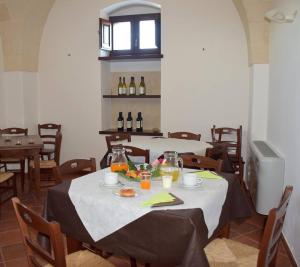 リッツァーノにあるMasseria San Vito - Agriturismoのダイニングルーム(テーブル、食べ物、ワインボトル付)