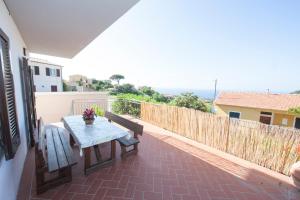 een patio met een tafel en een bank op een balkon bij casa la Rosa dei venti in Marciana