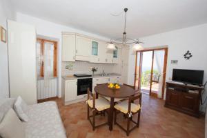 a kitchen and living room with a table and chairs at casa la Rosa dei venti in Marciana