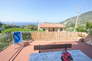 a patio with a bench and a table and a house at casa la Rosa dei venti in Marciana