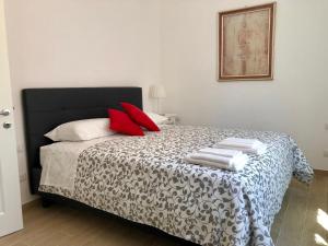 Un dormitorio con una cama con almohadas rojas. en Temporary House de' Giudei, en Bolonia