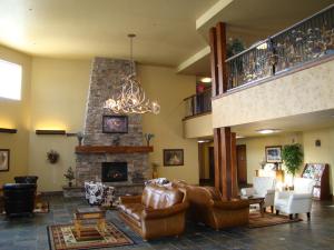 een woonkamer met lederen meubels en een open haard bij StoneCreek Lodge in Missoula