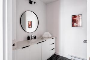 a bathroom with a mirror, sink, and cabinet at Maison Saint-Vincent By Maisons & co in Montreal