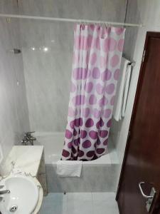 y baño con cortina de ducha y lavamanos. en Hotel Conforto Latino en Abrantes