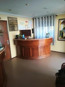 a lobby with a large wooden counter in a room at Hotel Conforto Latino in Abrantes