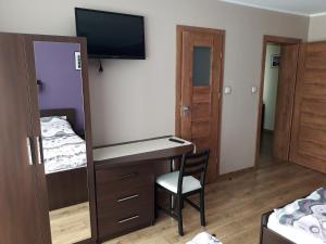 a bedroom with a desk and a mirror at U ELŻBIETY in Łeba