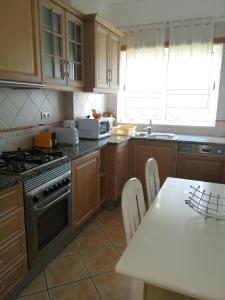 a kitchen with wooden cabinets and a table and a stove at Jardim Paraiso Apartments in Albufeira