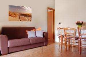 un soggiorno con divano e tavolo di Portorosa Apartments Helene a Furnari