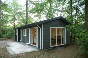 a green tiny house in the woods at t'Bakkersboschje nummer 9 in Putten