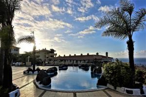 uma piscina com palmeiras e um edifício em Holiday home Los Frailes em Puerto de la Cruz