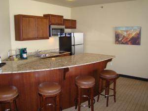 a kitchen with a counter with stools and a refrigerator at StoneCreek Lodge in Missoula