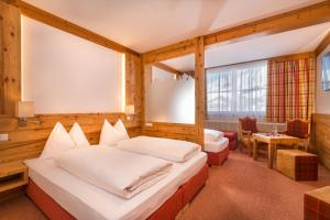 a hotel room with a bed and a table at Hotel Garni Haus Tyrol in Obertauern