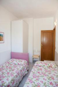 1 dormitorio con 2 camas y armario de madera en Casa Danilo, en Chiessi