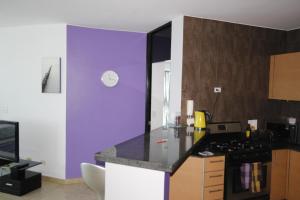 cocina con paredes de color púrpura y encimera en Playa Blanca Resort en Río Hato