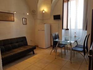 salon z kanapą, stołem i lodówką w obiekcie Calì Nitta Storic w mieście Corigliano dʼOtranto