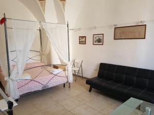 a living room with a bed and a couch at Calì Nitta Storic in Corigliano dʼOtranto