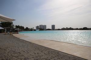 una piscina en una playa con edificios de fondo en Playa Blanca Resort en Río Hato