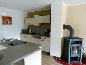 a kitchen with a stove in the middle of a room at Ferienwohnung Paul Schwarzenberg in Schwarzenberg