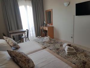 a hotel room with a large bed and a television at Miva Sea View in Faliraki