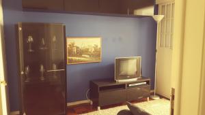 a living room with a tv and a blue wall at Apartamento Lisboa-Alameda in Lisbon