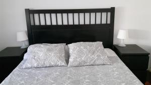 a bed with two pillows on it with two lamps at Apartamento Lisboa-Alameda in Lisbon