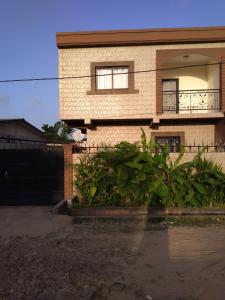 a brick house with a balcony on the side of it at Les pélerins in Pointe-Noire