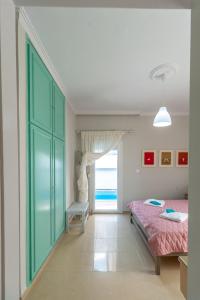 a bedroom with a bed and a large window at Skandalakis Homes & Apartments in Stalos