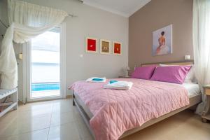 a bedroom with a bed with pink sheets and a window at Skandalakis Homes & Apartments in Stalos