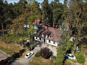 an overhead view of a house with cars parked in front at Gościnny Dworek in Pobierowo