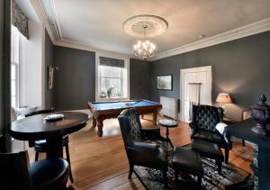 a living room with a pool table and chairs at Brockamour Manor Bed and Breakfast in Niagara on the Lake