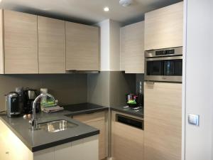 a kitchen with wooden cabinets and a sink at Cyrille et Vacances Presqu'ile de la Touques in Deauville