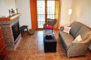 - un salon avec un canapé et une cheminée dans l'établissement Casa del Pino, à Pizarra