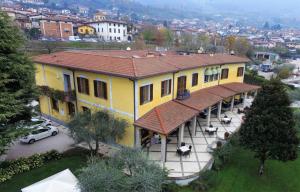 een groot geel huis met een dak bij Villa Kinzica in Sale Marasino