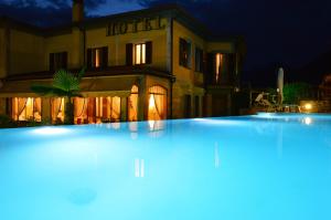 a large swimming pool in front of a hotel at night at Villa Kinzica in Sale Marasino