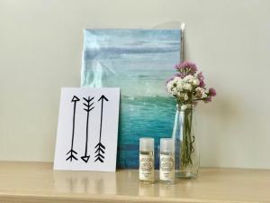 ein Tisch mit einer Karte und einer Vase mit Blumen und einem Gemälde in der Unterkunft Nazaré Beach Apartments in Nazaré