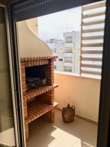 una chimenea de ladrillo en una habitación con ventana en Nazaré Beach Apartments, en Nazaré