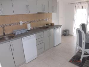 a kitchen with white cabinets and a sink and a chair at Raj in Kotor