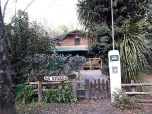 una señal frente a una casa con una valla en Cabaña La Strega en Tandil