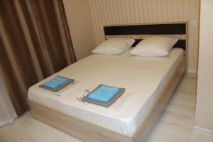a bedroom with a bed with two towels on it at Fish House Guest House in Gagra