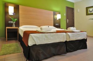 Habitación de hotel con 2 camas y toallas. en Hostal Ballesta, en Madrid