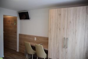 a room with a table and chairs and a wooden wall at Hotel Posta in Le Prese, Poschiavo