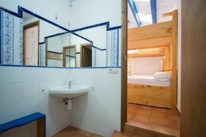 a bathroom with a sink and a bunk bed at Crux Albergue in Adahuesca