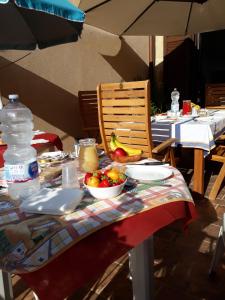 a table with a bowl of fruit and a chair at b&b Caravella in Mezzojuso