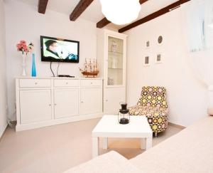 a living room with a tv and a chair at Little Summer House in Baška